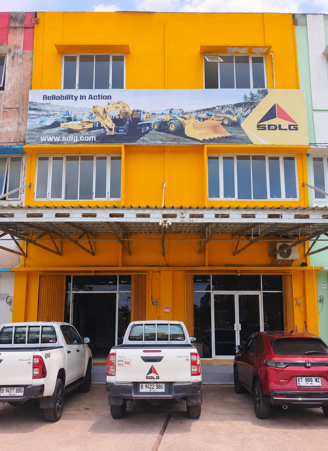 PT.SFJX regional office, yellow storefront and company vehicles